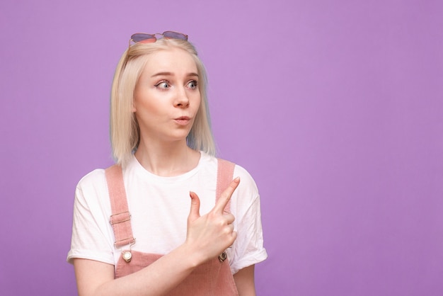 Portrait of surprised sweet lady showing thumb to the side