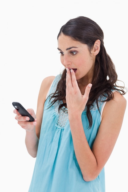 Portrait of a surprised woman reading a text message