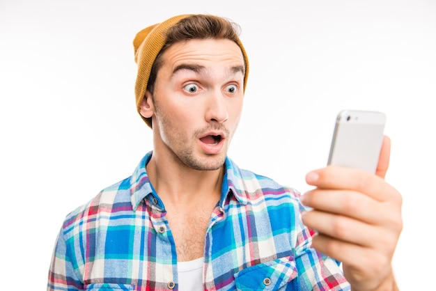 A portrait of surprised young man with mobile phone