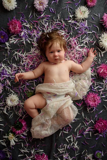 Portrait of a sweet little baby girl with a wreath of flowers