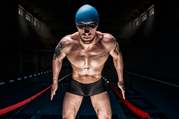 Portrait of a swimmer on the background of the pool.