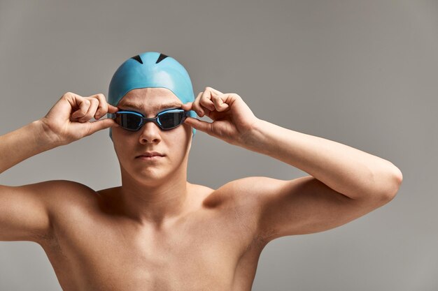 Foto ritratto di un nuotatore con un berretto e una maschera ritratto a mezza lunghezza di un giovane nuotatore atleta con un cappello e una mascherina