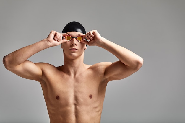 帽子とマスクをかぶった水泳選手の肖像画 半長肖像画 若いスポーツ選手の水泳選手が帽子をかぶって水泳選手をかぶっている