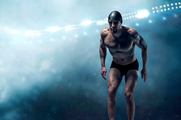 Portrait of a swimmer on a sports arena. Athlete is preparing for the jump.