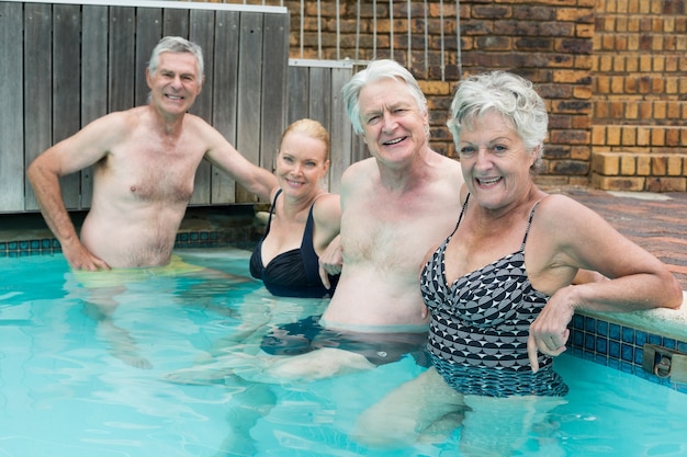 Portrait of swimmers leaning on poolside