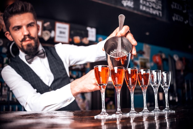 Portrait of tapster mixes a cocktail in the nightclub