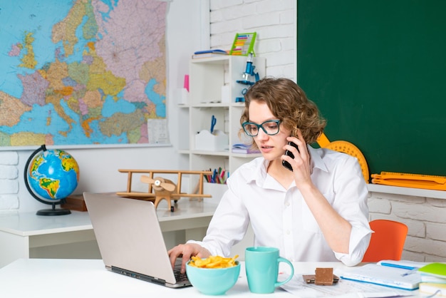 Portrait of teacher with mobile phone at school use laptop Education concept