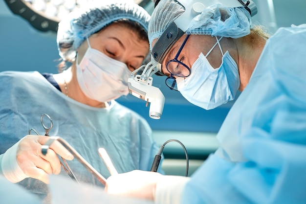 Portrait of team of multiethnic surgeons at work in a operation theatre Several doctors surrounding patient on operation table during their work Team surgeons at work in operating room