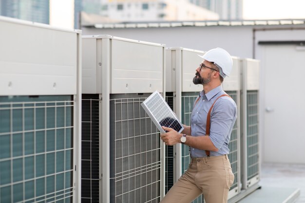 Portrait of Technician Electrical Engineer at rooftop building. Clean and green alternative energy concept.