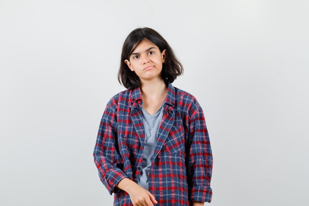 Photo portrait of teen girl frowning face, curving lips in casual clothes and looking displeased front view