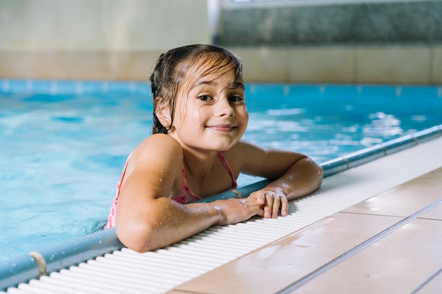 Portrait teen girl having fun in indoor swimming-pool.