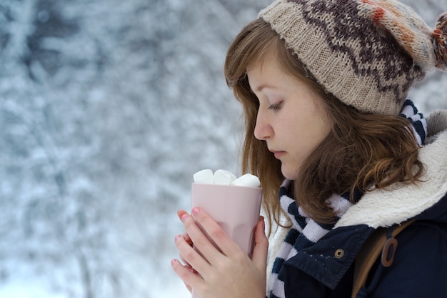 Портрет девушки-подростка, держащей в руках чашку с зефиром, рождество