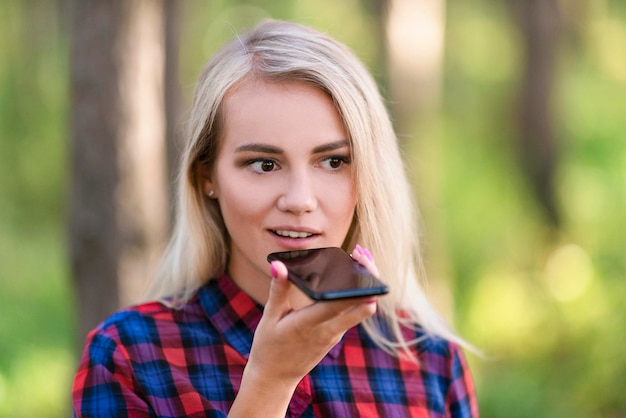 A portrait of a teen girl talking via speakerphone