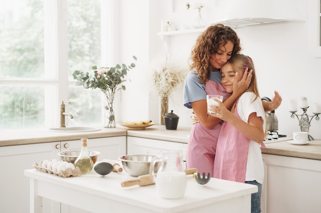 Photo portrait of a teen girl with her mother at home in kitchen