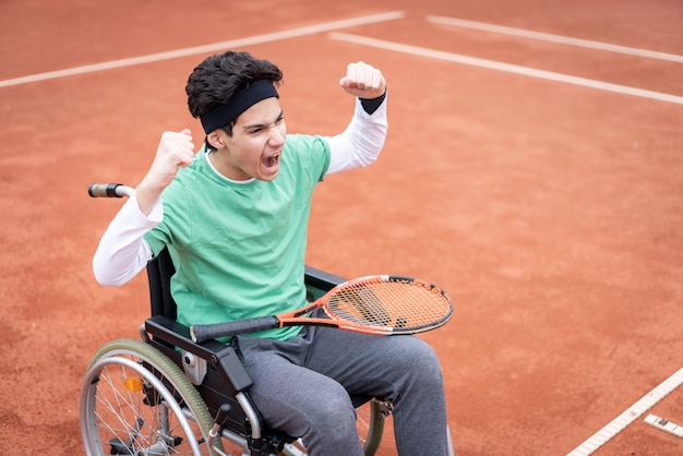 Un ritratto di adolescente in sedia a rotelle giocando a tennis