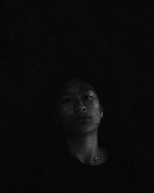 Photo portrait of teenage girl against black background