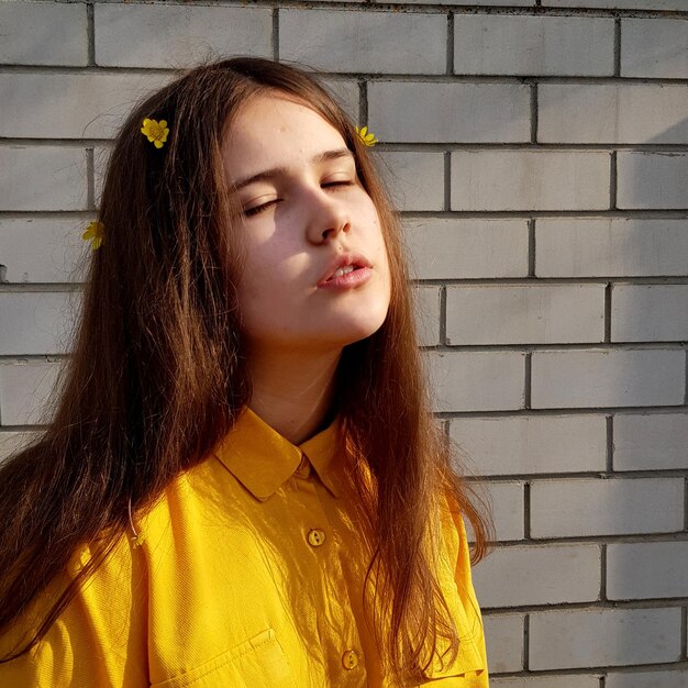 Portrait of teenage girl against wall