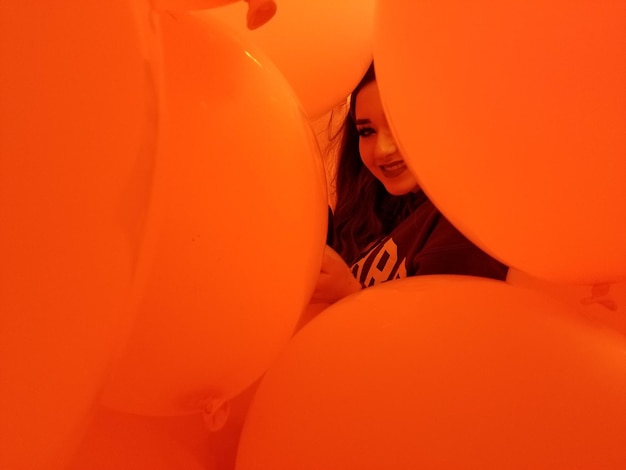 Portrait of teenage girl amidst orange balloons