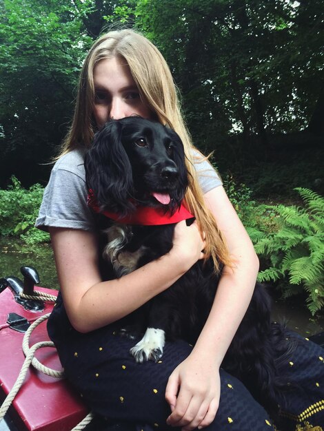 Photo portrait of teenage girl embracing dog