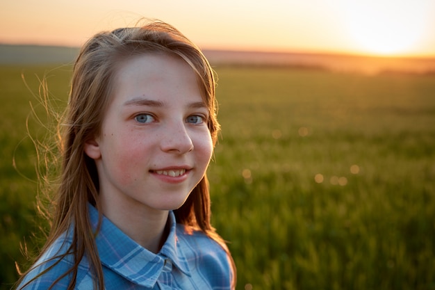 portrait of a teenage girl in a field at sunset