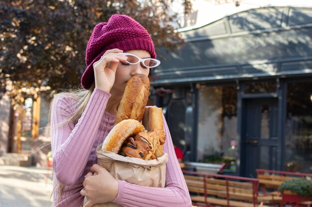 Photo portrait of a teenage girl inhales the aroma of freshly baked bread