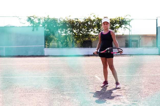 スポーツコートでテニスをしている10代の少女の肖像画