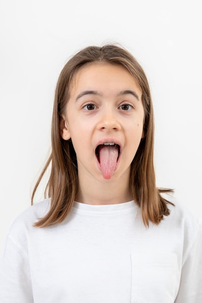 Portrait of a teenage girl showing her tongue isolated on a white background