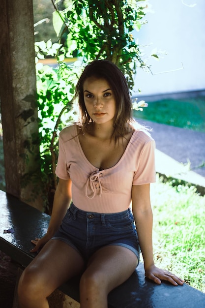 Portrait of teenage girl sitting on bench at park