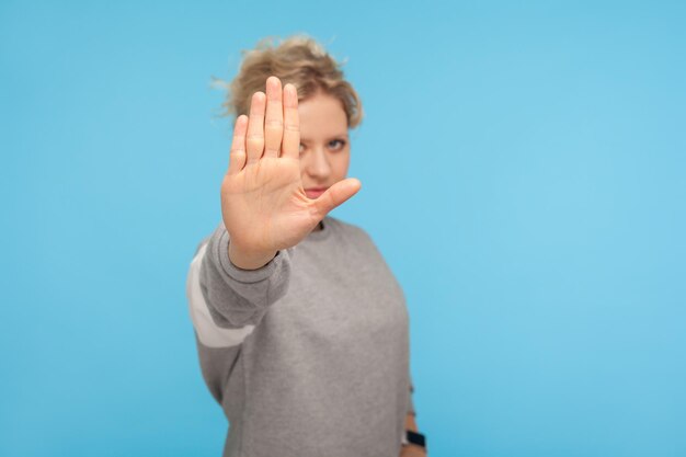 Portrait of teenage girl standing against blue background