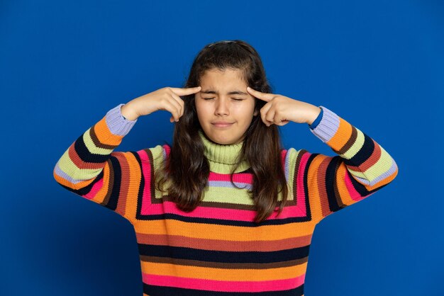 Portrait of teenage girl standing against blue background