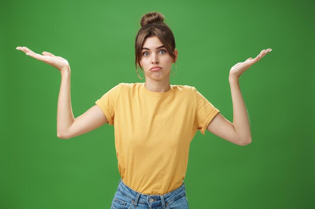 Portrait of teenage girl standing against green background