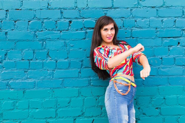 Portrait of teenage girl standing against wall