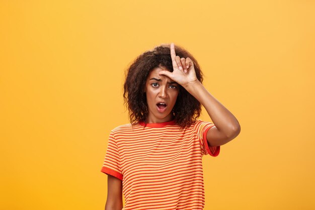 Portrait of teenage girl standing against yellow background