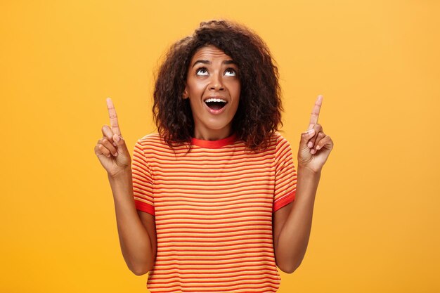 Portrait of teenage girl standing against yellow background