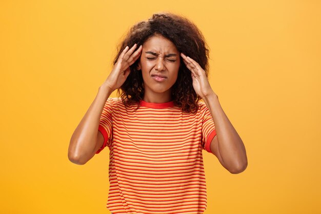 Portrait of teenage girl standing against yellow background