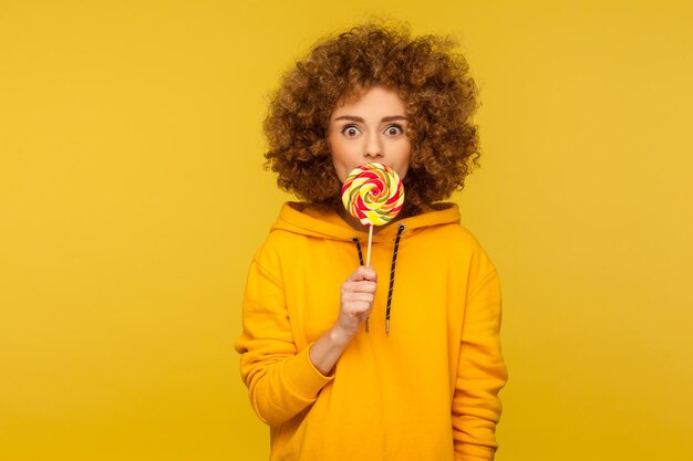 Portrait of teenage girl standing against yellow background