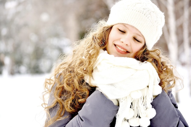 冬の風景を背景に白い帽子とスカーフで10代の少女の肖像画