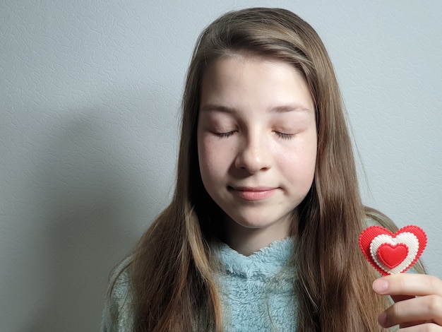 Portrait of a teenage girl with a heart in her hand