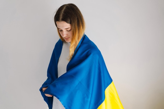 Portrait of a teenage girl with the ukrainian flag on a white background