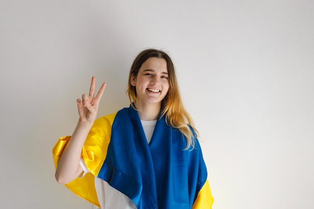 Portrait of a teenage girl with the ukrainian flag on a white background