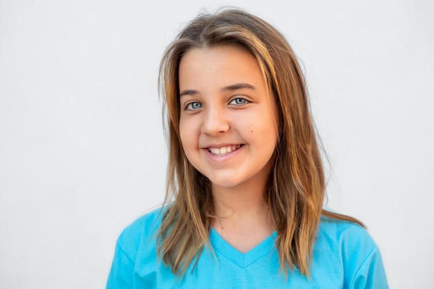 Portrait of a teenager girl smiling on a gray background