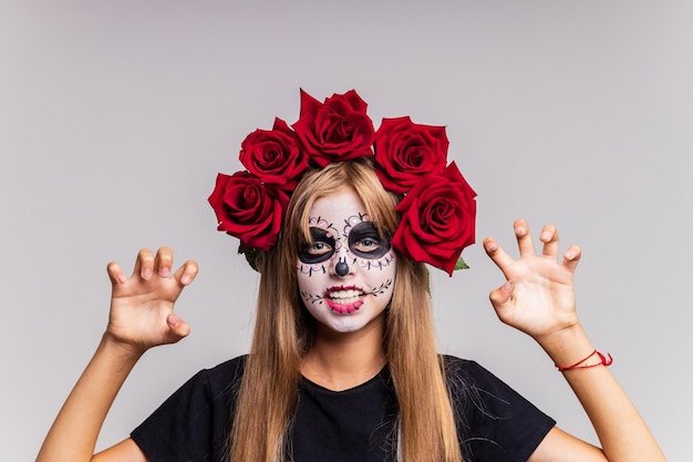 Portrait of teenager girl in a witch costume on studio background halloween make up