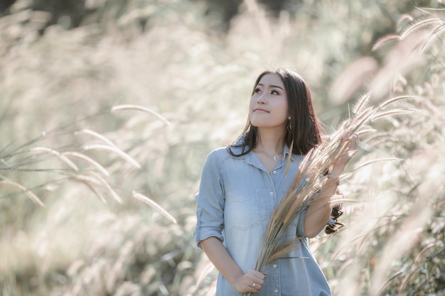 portrait thai model asian girl with grass posing and smiling in the garden 