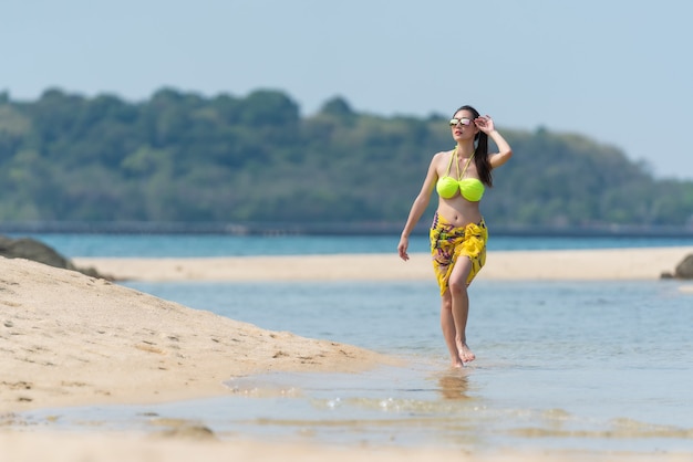 Portrait of thai woman in a bikini walking at the beach