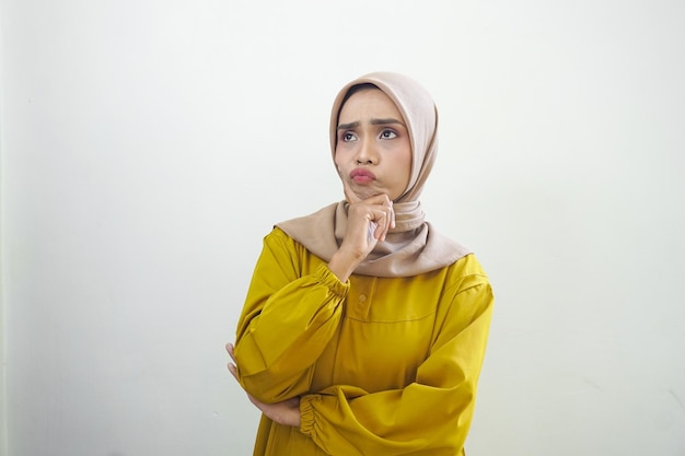 Portrait of thinking young Asian woman looking up and touch chin isolated by white background