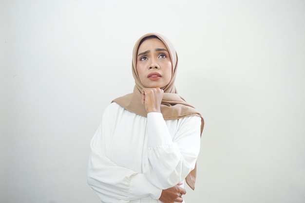 Portrait of thinking young Asian woman looking up and touch chin isolated on over white background