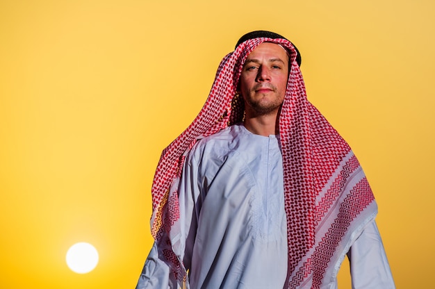 Portrait of thirsty Arabic man on a middle of yellow desert.