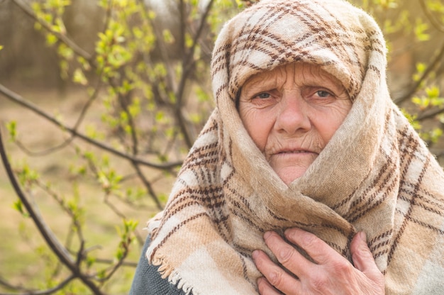 Portrait of thoughtful old grandmother leaning on cane