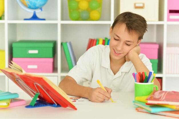 Portrait of thoughtful schoolboy doing homework at home