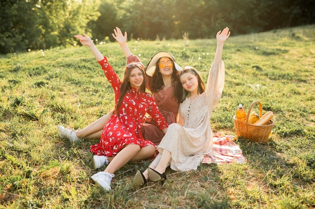 portrait of three beautiful young women in summer on a picnic